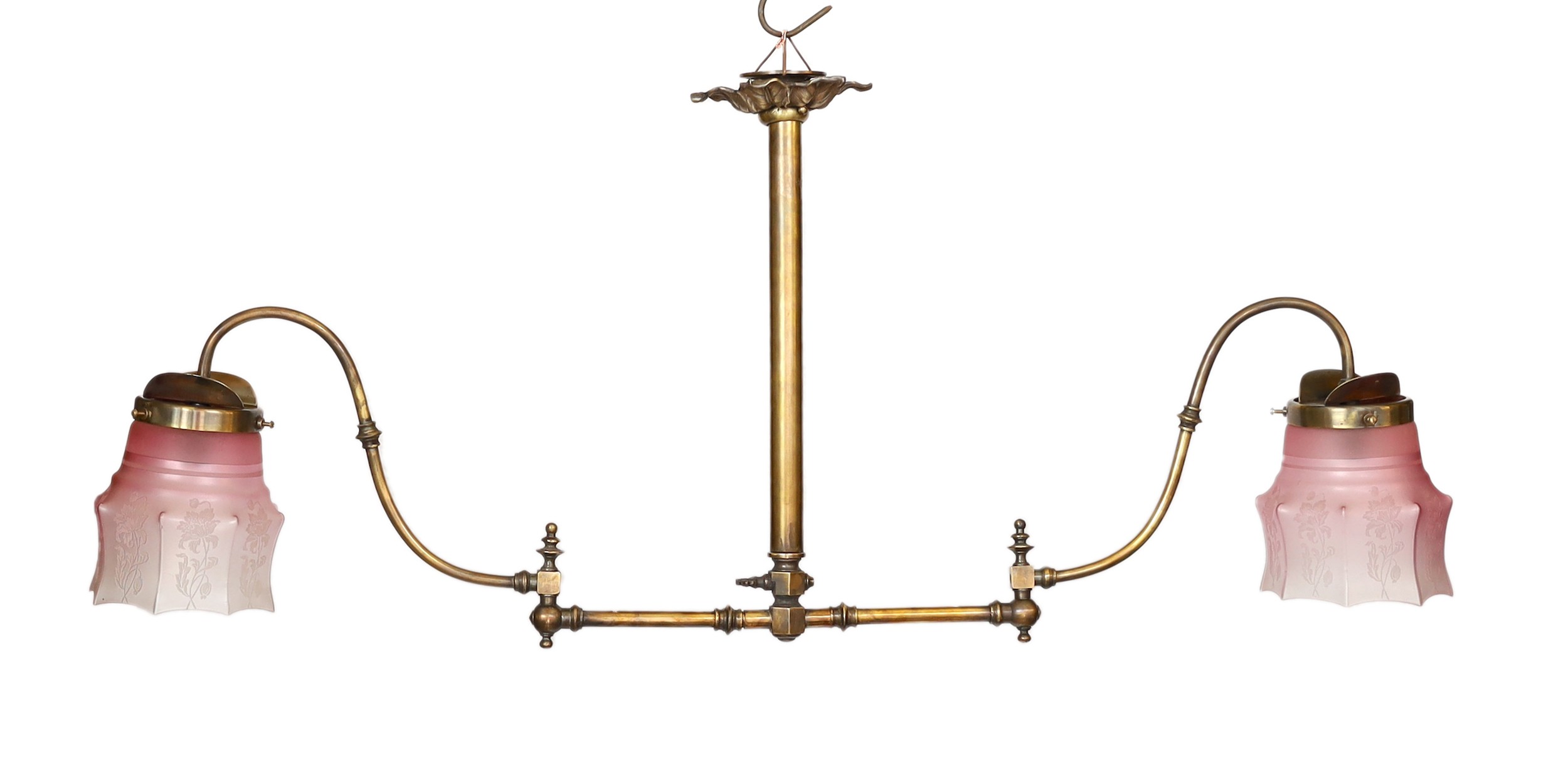 A late 19th century brass gasolier twin branch ceiling light with cranberry tinted etched glass shades, height 43cm. extends to 95cm